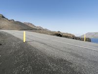 there is a bicycle on the side of a road that has been paved with a yellow pole