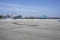 an industrial area with large ships and water in the background on a sunny day by the shore