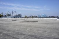 an industrial area with large ships and water in the background on a sunny day by the shore