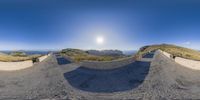 a panorama fisheye lens shot looking down a path in the distance is a scenic view of a valley