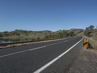 a view from a motorcycle's side road showing a sign in the middle of the road