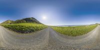 360 - view of gravel road with mountain range in the background with blue sky and cloud