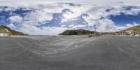 a fish eye lens is shown to show a road and the view of mountains, sand, and beach