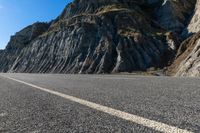 a road with rocks on the top and white stripeing and yellow stripeing between two sides