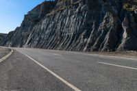 a road with rocks on the top and white stripeing and yellow stripeing between two sides