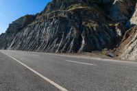 a road with rocks on the top and white stripeing and yellow stripeing between two sides