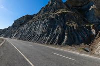 a road with rocks on the top and white stripeing and yellow stripeing between two sides