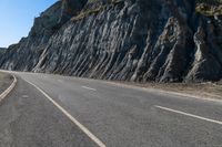 a road with rocks on the top and white stripeing and yellow stripeing between two sides