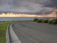 a winding city street with an ocean in the background on a cloudy day in august