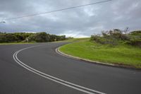 an empty road that looks like it's winding down to the left with traffic on it