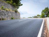 the asphalt road is paved with thin strips of white paint and has no cars driving on it