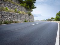 the asphalt road is paved with thin strips of white paint and has no cars driving on it