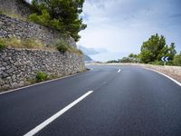the asphalt road is paved with thin strips of white paint and has no cars driving on it