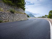 the asphalt road is paved with thin strips of white paint and has no cars driving on it