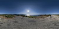 this 360 - shot has a blue sky and clear water in the background, as seen from a fish eye perspective