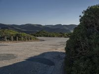 a scenic shot of the road going up hill side to the ocean on a beautiful day