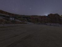 the long exposure lens on a road, with a mountain side in the background and a clear sky