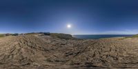 truck on the road next to an ocean and sky with the sun going down at some cliffs