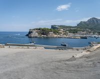 a paved road beside some large boats and a bridge with a bridge to the water