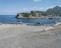 a paved road beside some large boats and a bridge with a bridge to the water