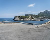 a paved road beside some large boats and a bridge with a bridge to the water