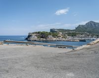 a paved road beside some large boats and a bridge with a bridge to the water