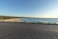 a road overlooking the beach and sand at sunset in an empty area with no people