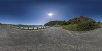 a panoramic photo of a wide open road next to the water and beach