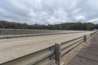 a freeway over the road with a wooden railing and railing around it to a forest