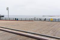 the wooden floor of a pier with a yellow surf board in the water behind it