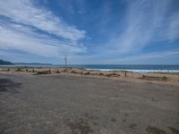 an empty lot with a beach and ocean in the background at the edge of it