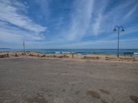 an empty lot with a beach and ocean in the background at the edge of it