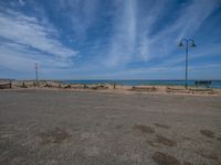 an empty lot with a beach and ocean in the background at the edge of it