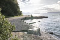 a bike leans up against a bench on the shore of a large body of water