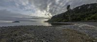 an image of an ocean view from the shore line at low tidetime with sun beams coming through the clouds