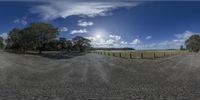 a wide angle shot of a dirt road in the sun with the sky behind it