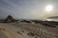 Coastal Sunrise: Rocky Shoreline of the Beach