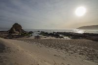 Coastal Sunrise: Rocky Shoreline of the Beach