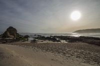 Coastal Sunrise: Rocky Shoreline of the Beach