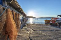 several lobster traps sit along the dock of a small fishing island at sunset by the water