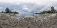 this is an oval mirror view of the water and rocks along with the road and beach