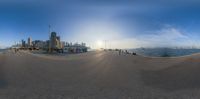 a panorama point effect image of the sun setting in the cityscape of an oceanfront town