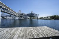 wooden dock extending out into the middle of the lake and some buildings in the background