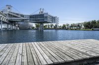 wooden dock extending out into the middle of the lake and some buildings in the background