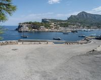 a paved road beside some large boats and a bridge with a bridge to the water