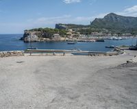 a paved road beside some large boats and a bridge with a bridge to the water