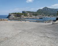 a paved road beside some large boats and a bridge with a bridge to the water