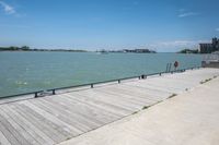 a bench and a view of some water and a dock that has buildings on it