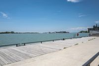 a bench and a view of some water and a dock that has buildings on it