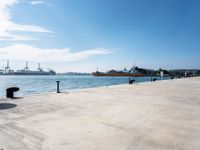 a view of a waterfront with buildings in the background and a bench near to them